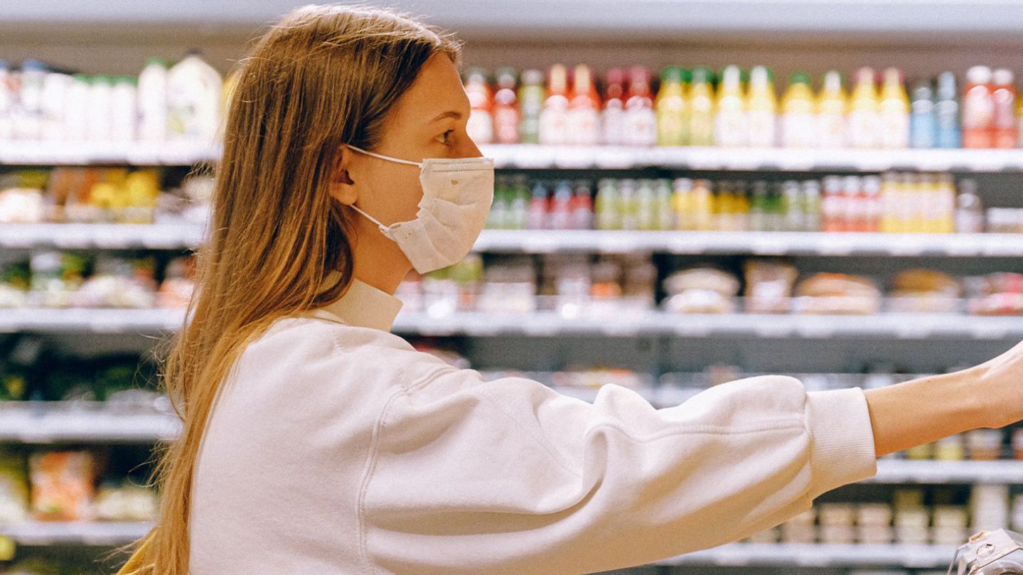 Women selecting orange at grocery store